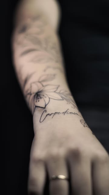 Flores delicadas com lettering no antebraço